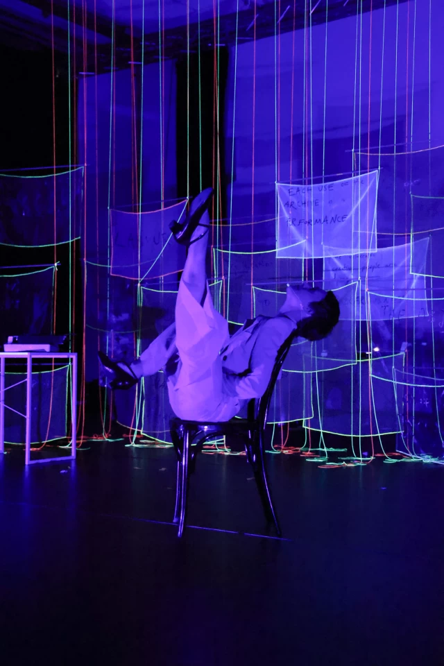 Britta performing the chair dance in blacklight, Tanzfabrik Berlin, June 2021 – photo by Anja Weber