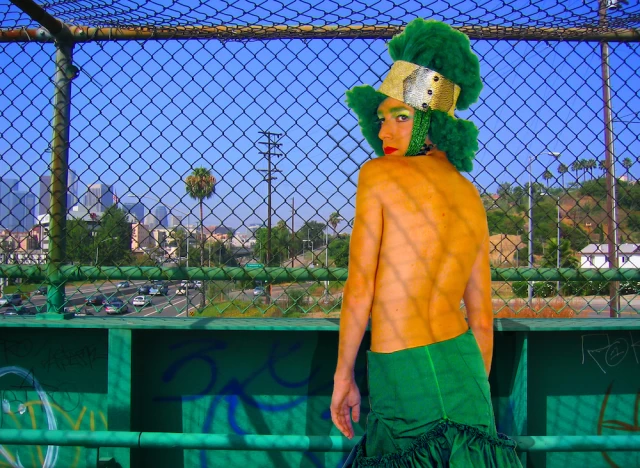 The Green Lady posing in a greenscreen studio with inserted background of freeway overpass in LA
