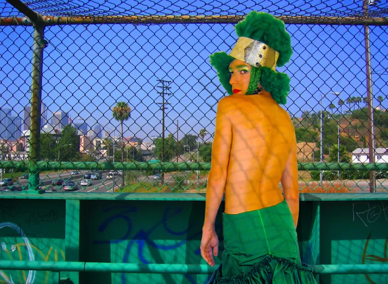 The Green Lady posing in a greenscreen studio with inserted background of freeway overpass in LA