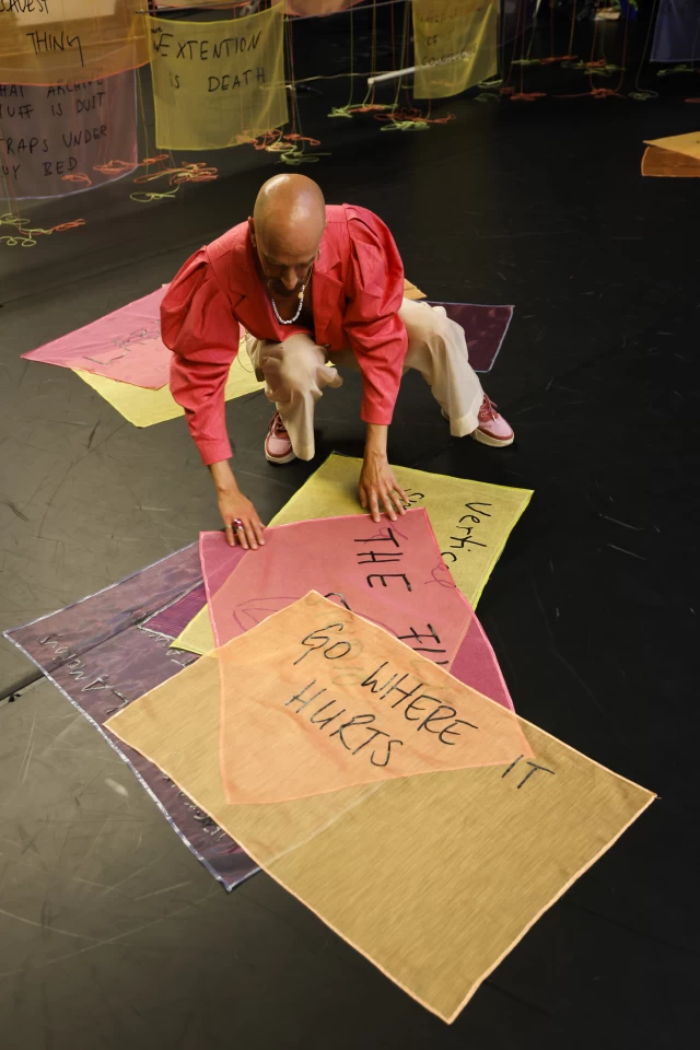 William arranging banners on the floor, Tanzfabrik Berlin, June 2021 – photo by Anja Weber