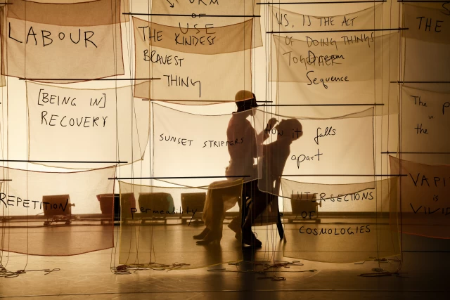 Britta and William performing the makeup scene behind banners, Tanzfabrik Berlin, June 2021 – photo by Anja Weber