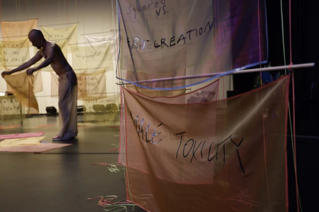 William arranging banners on the floor, Tanzfabrik Berlin, June 2021 – photo by Anja Weber