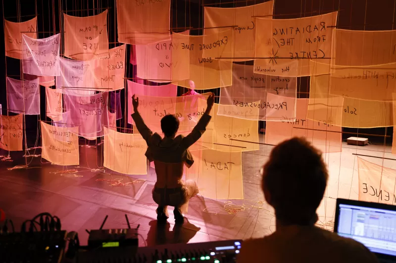 Britta holding a banner with sound and lighting designer Nikola Pieper in foreground, Tanzfabrik Berlin, June 2021 – photo by Anja Weber