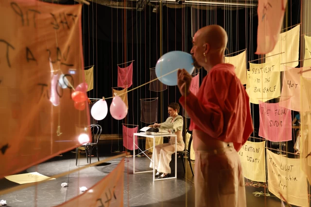 Britta performing the typewriter dance with william holding up clothesline with balloons, Tanzfabrik Berlin, June 2021 – photo by Anja Weber